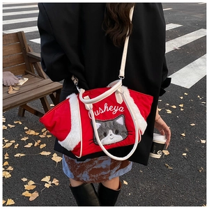 Dettaglio borsa shopper rossa trapuntata con ricamo a gatto e bordo in ecopelliccia