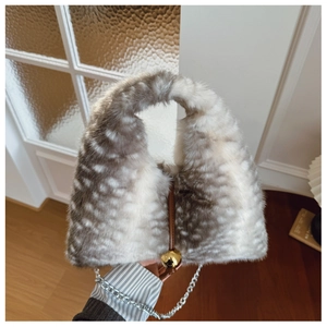 Détail du sac en fausse fourrure à motif cerf avec boule dorée et chaîne argentée