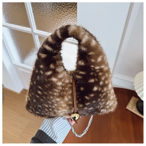Détail du sac à main en fausse fourrure avec taches léopard et breloque dorée