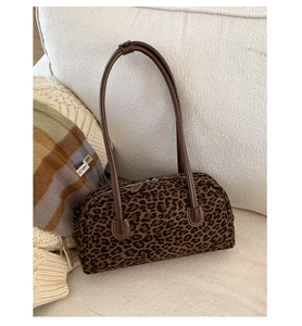 Close-up of leopard print baguette bag with premium leather straps and stitching details