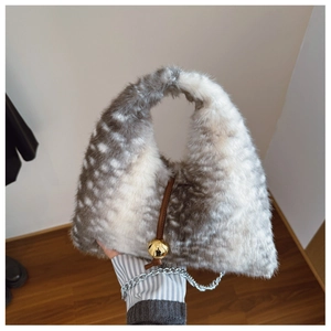 Détail du sac à main en peluche à pois gris avec pendentif sphère dorée