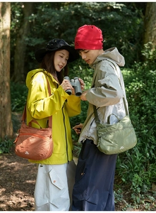 Detail of waterproof checkered crossbody bags in brick red and army green nylon
