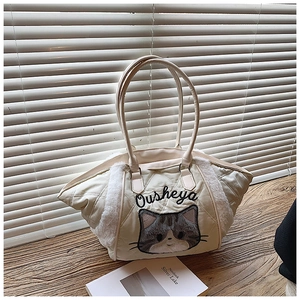 Dettaglio della borsa tote trapuntata crema con bordo in ecopelliccia e ricamo gatto