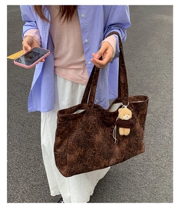 Street view of a large leopard print tote bag with a cute brown teddy bear charm