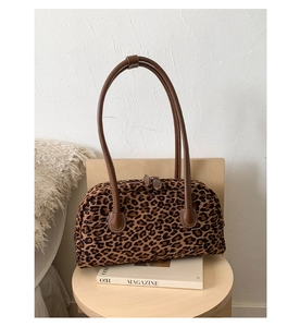 Detailed macro view of the vintage leopard print handbag with leather shoulder straps