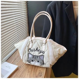 Dettaglio di borsa tote trapuntata crema con bordo in peluche e ricamo di un gatto