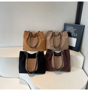 Four colors of frosted tote bags with metal chain straps on display stairs
