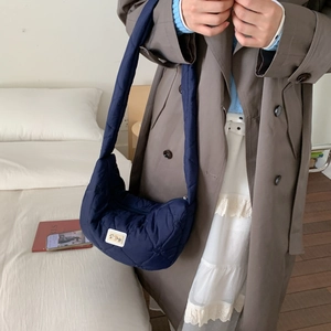 Navy blue heart quilted nylon puffer bag with wide shoulder strap and white logo patch
