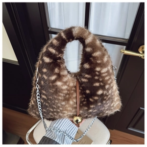 Détail du sac en fausse fourrure pelucheuse avec taches brunes et chaîne argentée