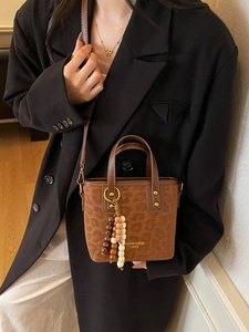 Stylish leopard print bucket handbag with wooden bead tassel and crossbody strap
