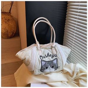 Dettaglio della borsa tote trapuntata verde chiaro con ricamo di gatto e bordo in ecopelliccia