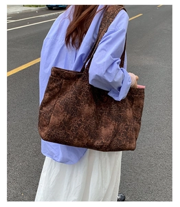 Outdoor street view of a large leopard print tote bag with wide shoulder straps for women