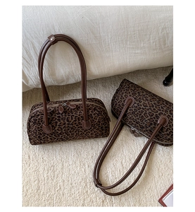 Close-up of retro cylinder baguette bags with leopard print and brown leather handles