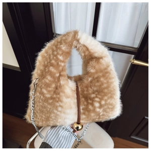 Détail de la texture en fausse fourrure avec chaîne argentée et pendentif boule dorée