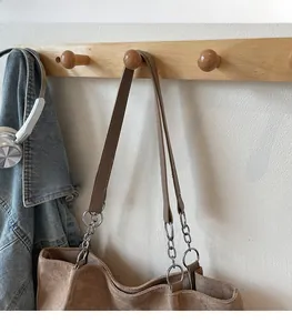 Detail of brown faux suede tote bag featuring premium leather straps and silver metal chain link