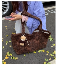 Detailed view of large leopard print tote bag with bear charm in casual street setting