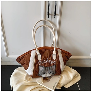 Dettaglio della borsa tote trapuntata caramello con ricamo di gatto e bordo in peluche