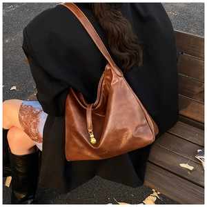 Vue détaillée du sac cabas marron en similicuir avec pendentif doré en forme de gourde