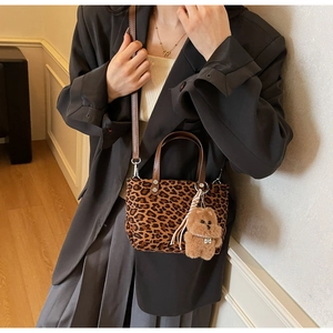 Dettaglio borsa leopardata in pelle scamosciata con cinturino e ciondolo a forma di orso