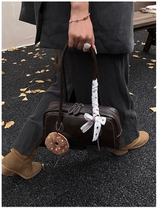 Détail du sac baguette marron rétro avec breloque donut en peluche et nœud en dentelle