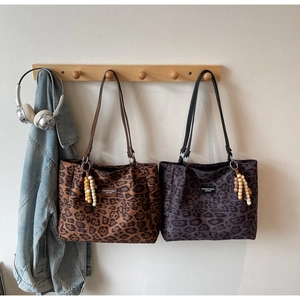 Detailed macro view of leopard print tote bags with premium logo and beaded charms
