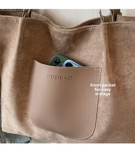 Close-up of front pocket on large brown tote bag showing smartphone storage detail