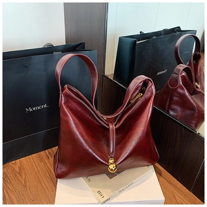 Sac cabas en cuir bordeaux avec finition brillante et détail élégant de pendentif doré