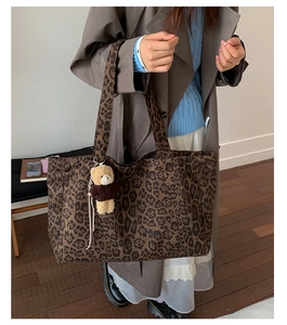 Close-up of large leopard print tote bag with a cute bear plush charm and dual straps