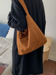 Grand sac hobo à imprimé léopard marron porté par un mannequin en intérieur