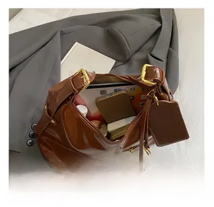 Detail view of spacious interior of brown waxed leather bag with gold buckle and tag