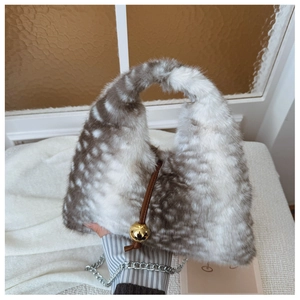 Détail du sac en fausse fourrure à motifs de cerf avec lanières en cuir et boules dorées