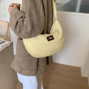 Detailed quilted heart patterns and pearl leather patch on a yellow shoulder bag