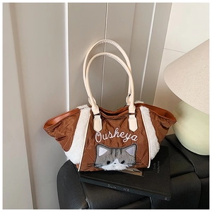Dettaglio ravvicinato della borsa tote trapuntata marrone con toppa gatto grigio e bordo in pelo