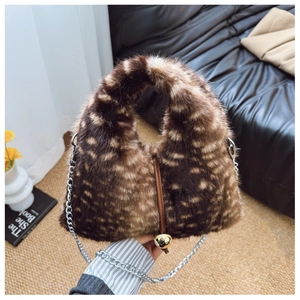 Détail du sac à main en fausse fourrure pelucheuse avec texture tachetée et boules dorées