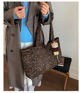 Close-up of large leopard print tote bag with cute plush bear keychain detail