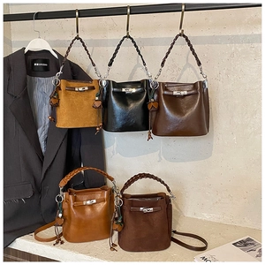 Detail showing five colors of bucket bags with metal turn-lock and woven handles