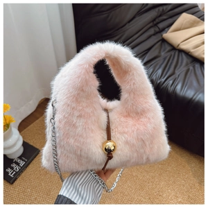 Détail du sac à main en fausse fourrure rose avec chaîne argentée et boule dorée