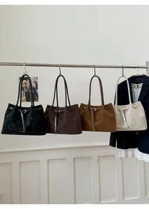 Four large capacity suede tote bags in black, coffee, caramel and cream hanging on a rack
