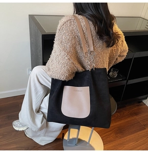 Detail of contrast tote bag with suede finish and leather chain strap shown on model