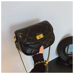 Detail of black quilted leather crossbody bag featuring gold chain and turn-lock closure