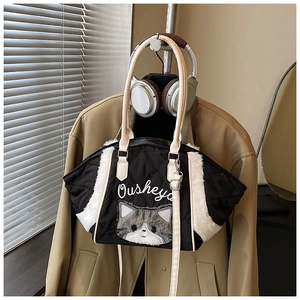 Dettaglio borsa shopper nera trapuntata con finiture in ecopelliccia e patch a gatto