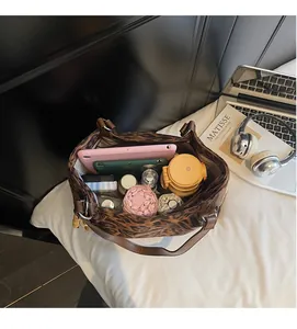 Top-down view of a spacious leopard print tote bag interior filled with daily essentials