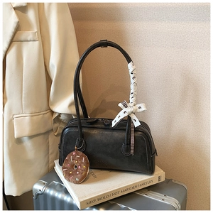 Détail du sac baguette gris foncé avec coutures contrastées et nœud en dentelle