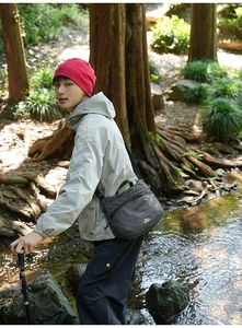 Outdoor waterproof messenger bag paired with hiking outfit in forest scene detail