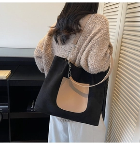 Detail of minimalist tote bag showing the brand logo on a beige leather pocket