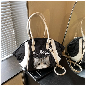 Dettaglio borsa tote trapuntata nera con bordo in ecopelliccia e ricamo a gatto