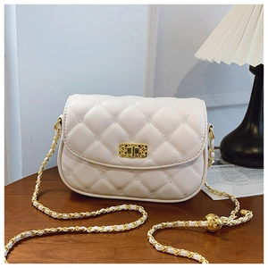 Detail of quilted beige crossbody bag with gold chain strap and metal toggle