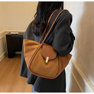 Detail shot of the brown suede bucket bag featuring a gold metal buckle and leather trim