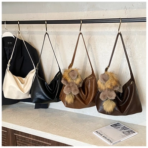 Vue détaillée de grands sacs cabas en cuir en quatre couleurs avec breloques en fourrure