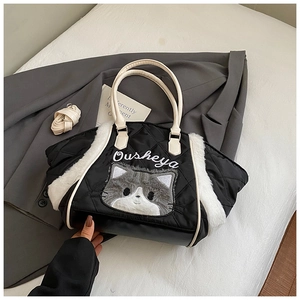 Dettaglio borsa tote trapuntata nera con ricamo gatto grigio e bordo in ecopelliccia bianca